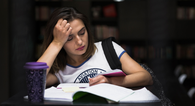girl sitting table with notebooks reading