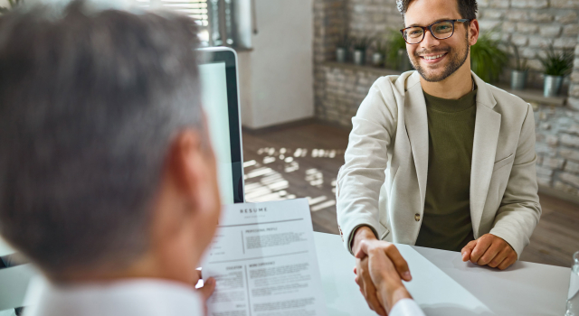 happy male candidate greeting member human resource team job interview office