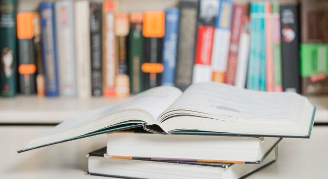 textbooks lying near bookcase