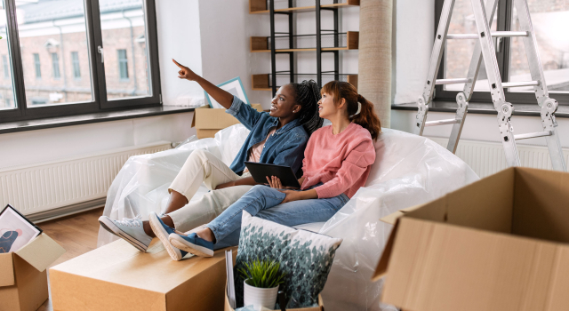 women with tablet pc moving new home