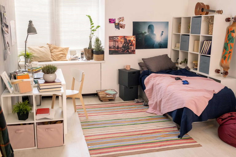 spacious bedroom teenage student with bed desk with lamp laptop other stuff