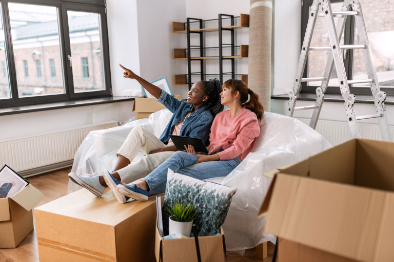 women with tablet pc moving new home